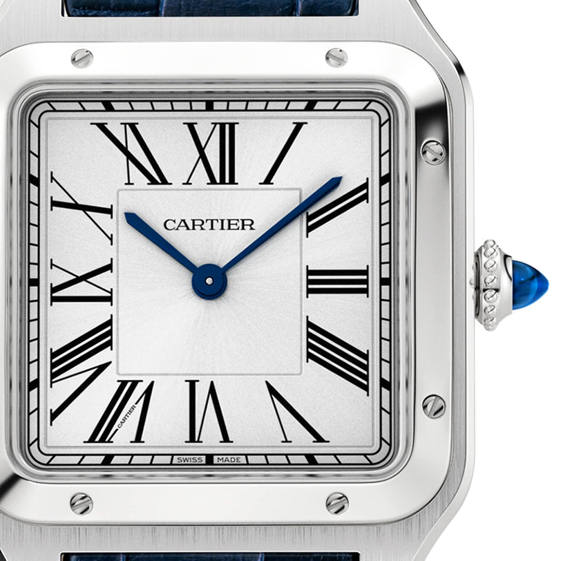 Close-up of a Cartier Santos-Dumont watch face with Roman numerals, blue hands, a silver square bezel, and a blue cabochon crown on the right side.