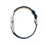 A side view of the Cartier Santos-Dumont watch displays its blue leather strap, silver case, and distinctive blue crown.