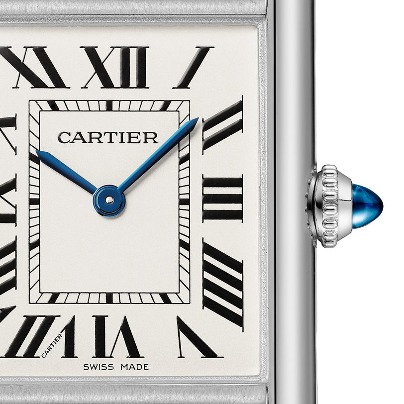 Close-up of the Tank Must de Cartier watch by Cartier, featuring blue hands, Roman numerals, Swiss Made text, a blue cabochon crown on the right, and a sleek steel case with precise quartz movement.