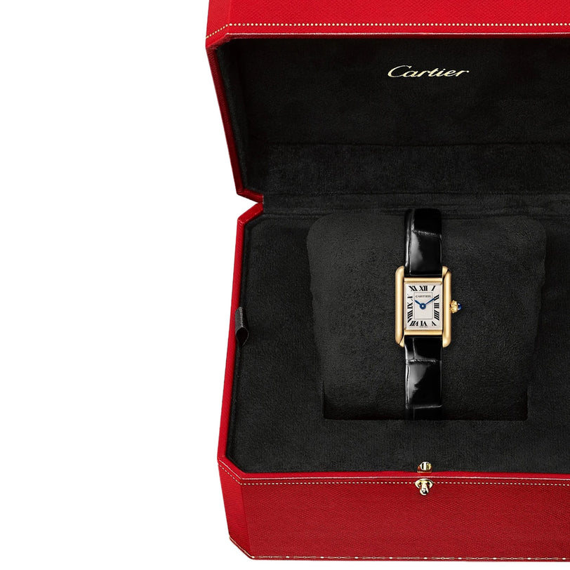 The Cartier Tank Louis Cartier watch, featuring a rectangular yellow gold case and a black alligator leather strap, is presented on a black cushion inside a red Cartier box.