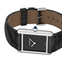 The Tank Must de Cartier by Cartier features a black alligator-skin strap, a rectangular silver case, a black dial with silver hands, and the signature blue cabochon crown.