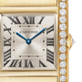 Close-up of the Cartier Tank Française watch, featuring Roman numerals, blue hands, and a gold case set with diamonds.