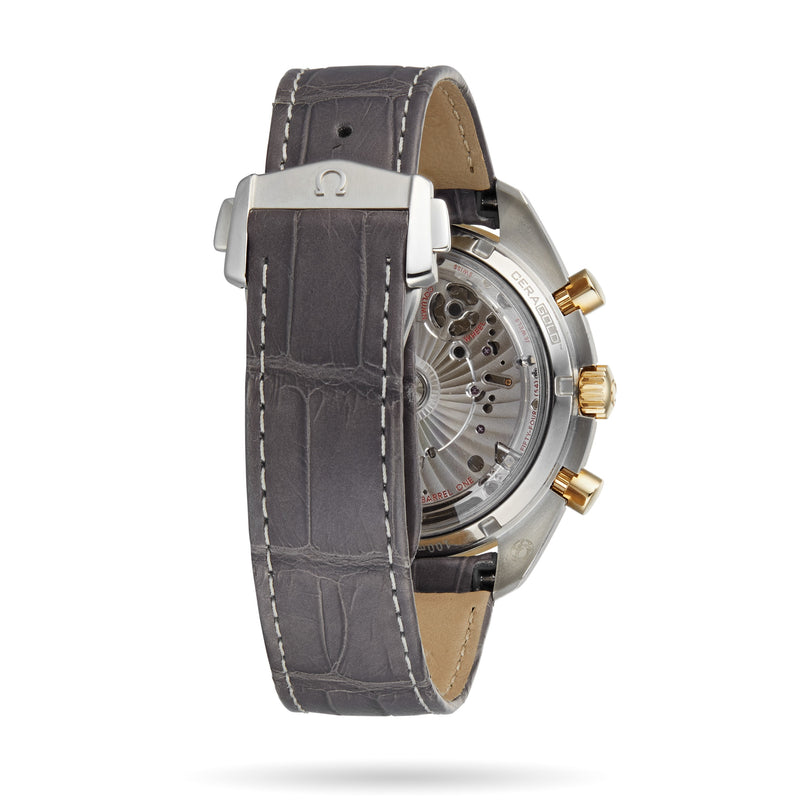 A close-up of the OMEGA Speedmaster Moonphase’s back, featuring a grey leather strap, 18K yellow gold accents, and a transparent case that reveals the watch’s Moonphase mechanism.