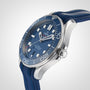 A close-up of the OMEGA Seamaster Diver 300M, featuring a blue face, blue bezel, and blue rubber strap with the precise Calibre 8800 movement, angled on a plain light background.