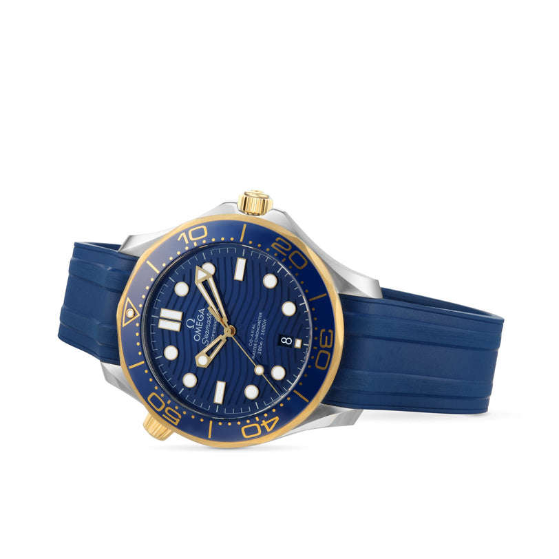 The OMEGA Seamaster Diver 300M is a luxury watch featuring a blue rubber strap, gold and silver bezel, blue dial with time, date, luminescent hour markers—all powered by the Master Chronometer 8800 calibre movement.