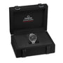 A stainless steel Speedmaster Moonwatch Professional by OMEGA is shown in an open black presentation box featuring the OMEGA logo and name on the inside lid.