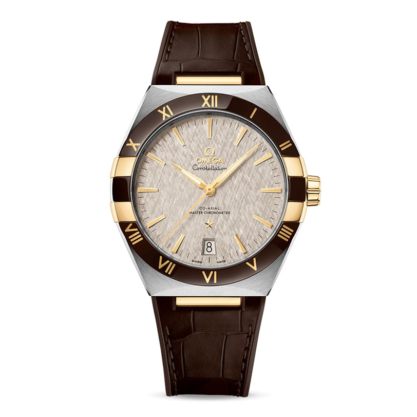 The OMEGA Constellation features a textured silver dial with gold Roman numerals, date at 6 o’clock, black bezel, and brown leather strap, inspired by its heritage and powered by the Master Chronometer 8900 calibre movement.