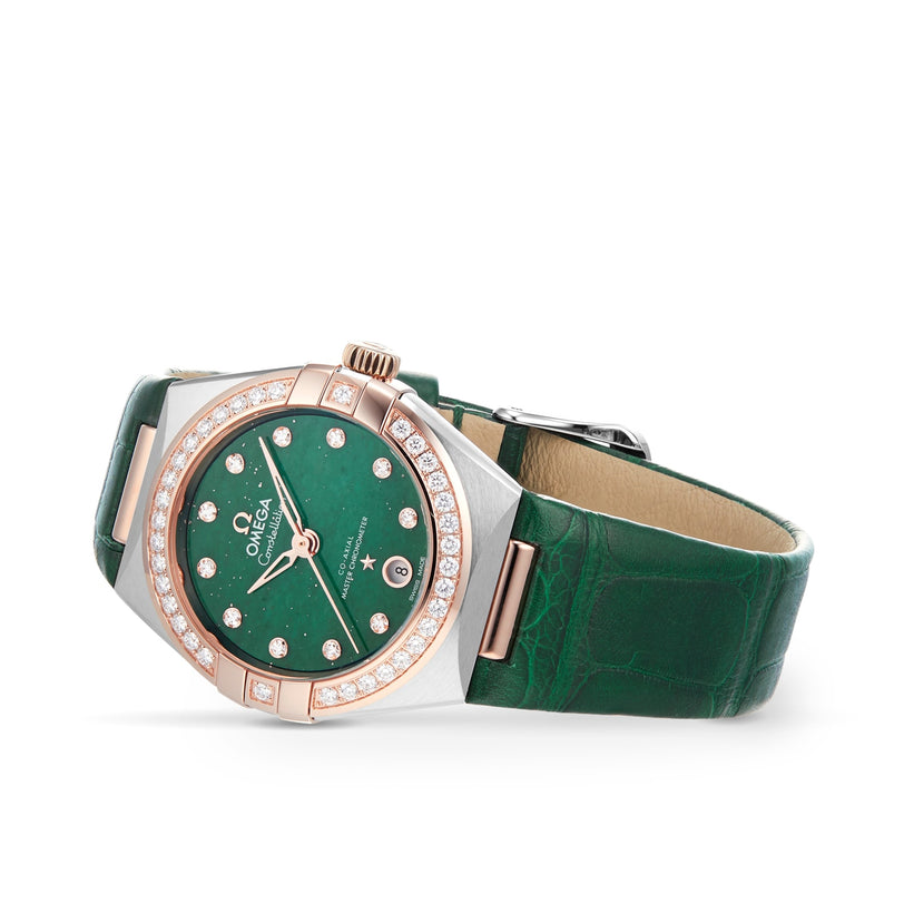 The OMEGA Constellation features a green leather strap, green dial, 18K Sedna™ gold diamond-set bezel, date at 6 oclock, and is Master Chronometer certified for outstanding precision and style.