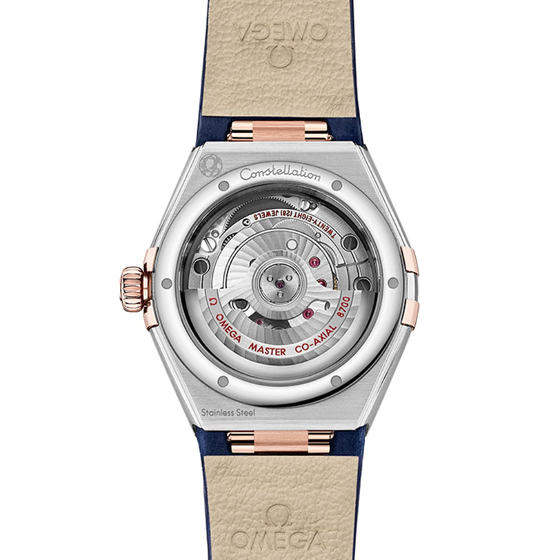 The image shows the back of an OMEGA Constellation watch, revealing its exposed mechanical movement and Master Co-Axial engravings on the stainless steel case.