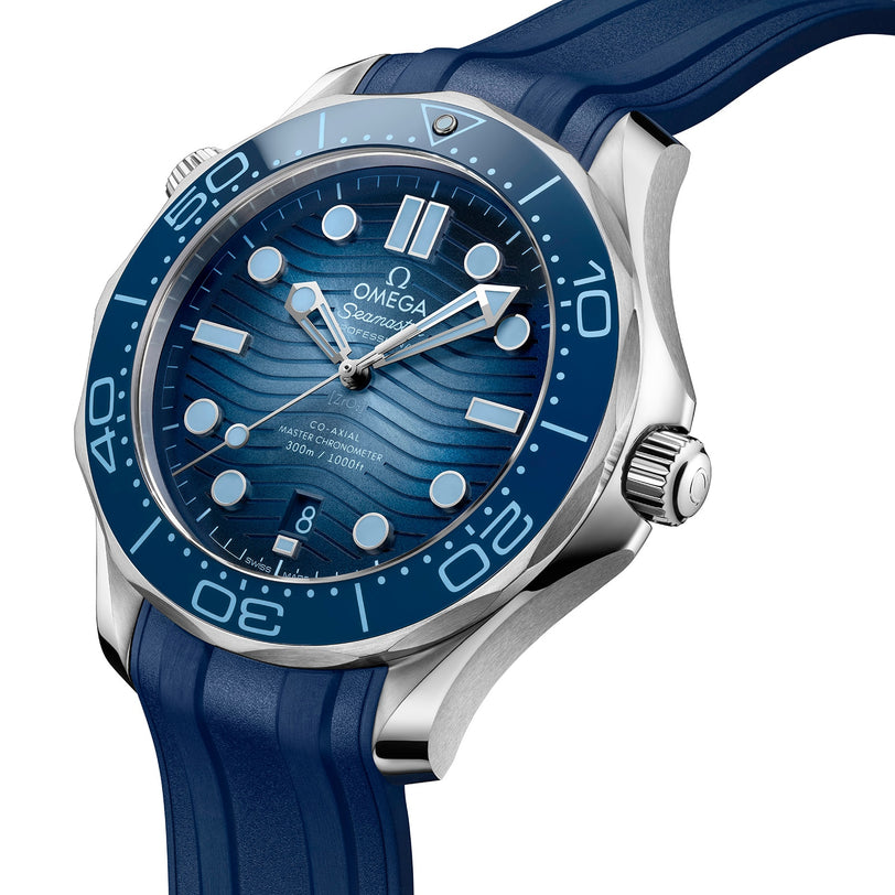The OMEGA Seamaster Diver 300M Summer Blue features a wave-patterned blue dial, white markers and hands, silver bezel, and a blue rubber strap—blending precision and style as a certified Master Chronometer.