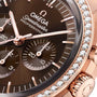 Close-up of the OMEGA Speedmaster Moonwatch Professional with a brown dial, three subdials, diamond-set 18K Sedna Gold bezel, and OMEGA Co-Axial Master Chronometer Calibre 3861 movement.