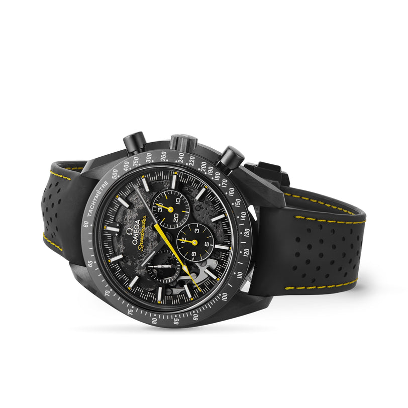 An OMEGA Speedmaster Moonwatch Apollo 8 Dark Side Of The Moon chronograph, featuring yellow accents and a perforated rubber strap, is shown on a white background.