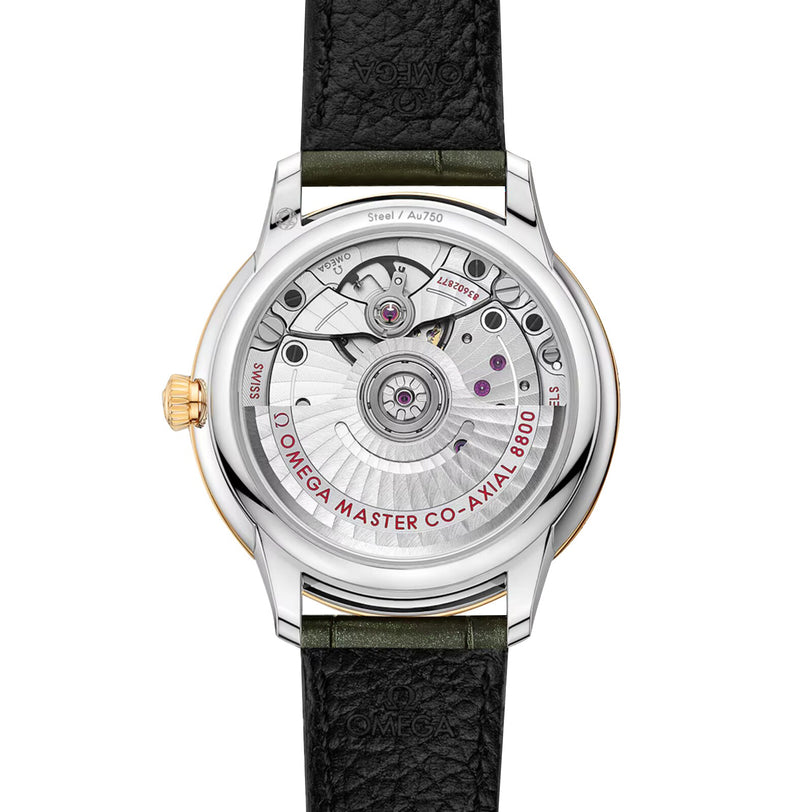 The OMEGA De Ville Prestige features a striking 18K yellow gold and steel case, an exposed Master Chronometer movement engraved with Omega Master Co-Axial 8800, and a black leather strap.