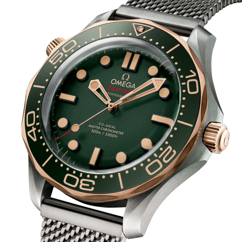Close-up of the OMEGA Seamaster Diver 300M with green dial, 9K Bronze Gold bezel, mesh strap, and water resistance up to 300 meters. This watch is a Co-Axial Master Chronometer.