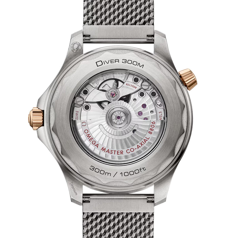 The OMEGA Seamaster Diver 300M features a transparent case back that displays its Co-Axial Master Chronometer movement, complemented by a sleek metal mesh strap.