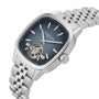 The Raymond Weil Freelancer Calibre RW1212 features a robust masculine case, blue dial with silver hour markers, visible tourbillon mechanism, and metal link bracelet—ideal for fans of distinctive mechanical watches.