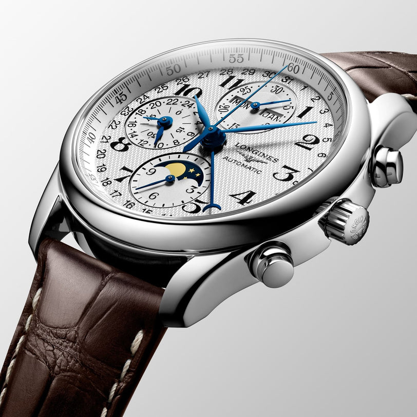 A close-up of the Longines Master Collection Chrono Moonphase, featuring a stainless steel case, brown leather strap, blue hands, chronograph subdials, and an elegant moon phase display.