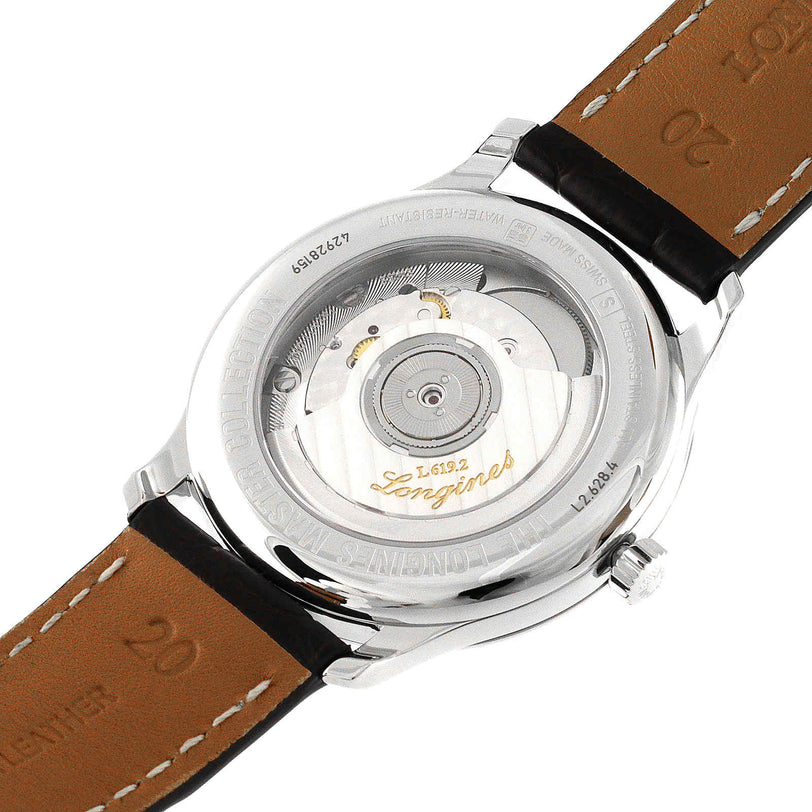 The Longines Master Collection watch features a transparent case back, displaying its intricate mechanical movement and engraved stainless steel rim.