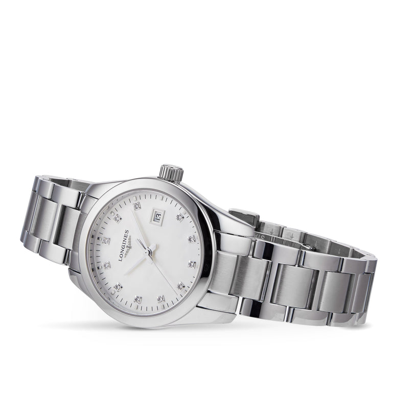 A Longines Conquest Classic wristwatch with a stainless steel case, silver bracelet, white dial, date display, and diamond hour markers is elegantly photographed on a white background.