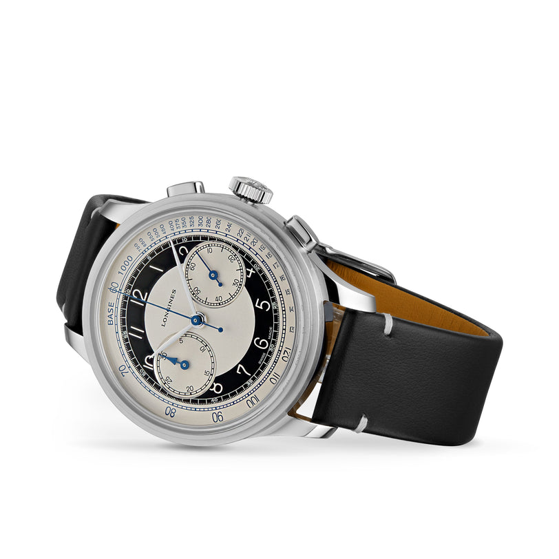 The Longines Tuxedo is a stainless steel wristwatch from the Heritage Classic collection, featuring a black leather strap, black and white dial with three subdials, blue hands, and calibre L895 automatic movement, shown on a white background.