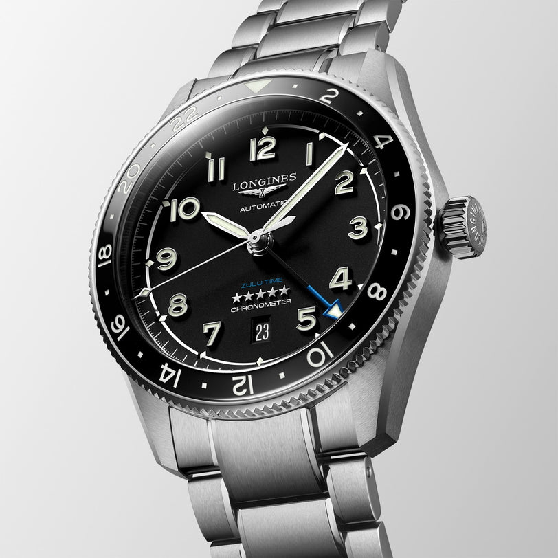 A close-up of the Longines Spirit Zulu Time automatic watch featuring a black dial, stainless steel case and bracelet, date display, and bold hour markers enhanced with Swiss Super-LumiNova.