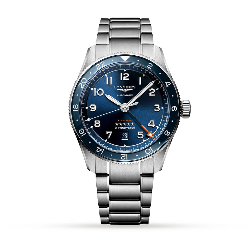 The Longines Spirit Zulu Time wristwatch features a stainless steel case, blue dial with silver Super-LumiNova markers, date at 6 o’clock, and a metal bracelet, displayed on a white background.