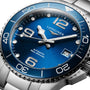 Close-up of a Longines HydroConquest wristwatch with a sunray blue dial, silver markers, date window, and stainless steel diving bezel (300m/30 bar), powered by the Calibre L888 automatic movement.