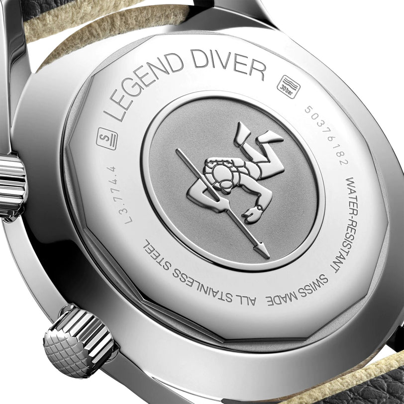 Close-up of the Longines Legend Diver watch caseback engraved with a diver holding a spear, showing stainless steel build, water resistance, serial info, and highlighting the L888 calibre movement inside.