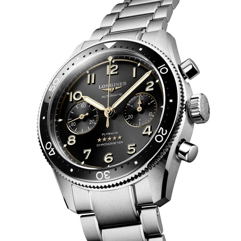 The Longines Spirit Flyback is a stainless steel chronograph wristwatch with a black dial, luminous Arabic numerals, three subdials, and a metal bracelet, inspired by the brands aviation heritage.