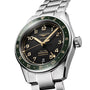 The Longines Spirit Zulu Time is a stainless steel watch with a green ceramic bezel, black dial, gold numerals, and date display at 6 o’clock.