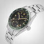 A Longines Spirit Zulu Time stainless steel watch, featuring a green ceramic bezel, black dial, gold numerals, and date display by Longines, is photographed at an angle against a plain background.