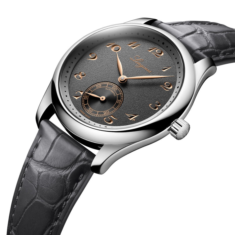 A close-up of the Longines Master Collection wristwatch, featuring a black leather strap, anthracite dial with gold Arabic numerals, silver case, and displaying hours, minutes, and a small seconds subdial.