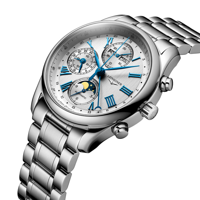 The Longines Master Collection Chrono Moonphase features a silver metal band, white dial with blue Roman numerals, multiple subdials, and an elegant moonphase display inspired by the collection’s automatic movement.