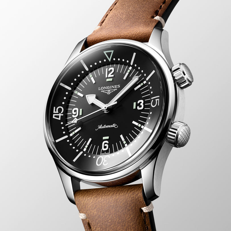 A close-up of the Longines Legend Diver, a vintage-inspired automatic dive watch with a black dial, luminous markers, and a brown leather strap.