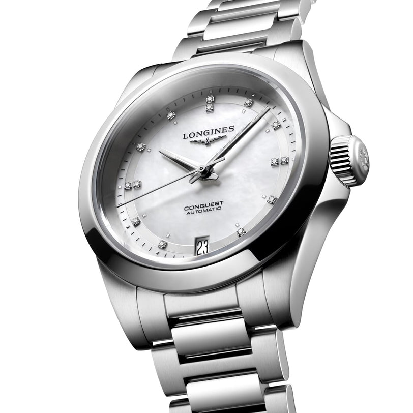 The Longines Conquest wristwatch features a silver case, white dial, diamond hour markers, and a date display at 6 o’clock.