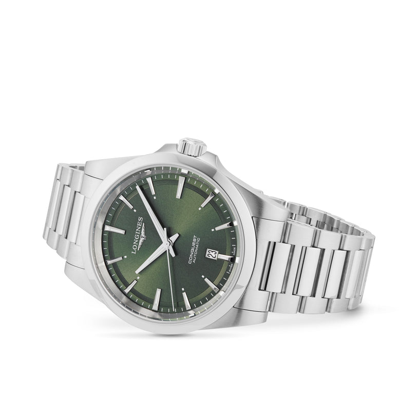 A Longines Conquest stainless steel wristwatch with a green dial, silver Swiss Super-LumiNova hour markers, and a date display at 3 o’clock lies at an angle on a white background.