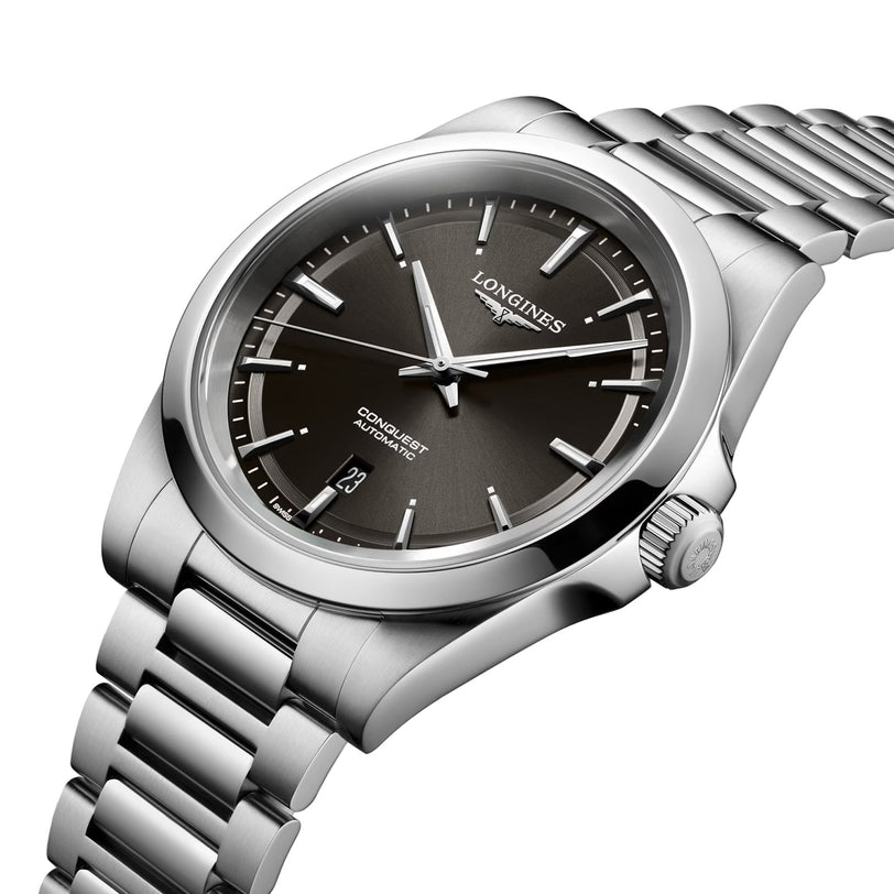 The Longines Conquest wristwatch features a stainless steel case, automatic movement, black dial with silver markers, date at 6 o’clock, and a metal link bracelet.