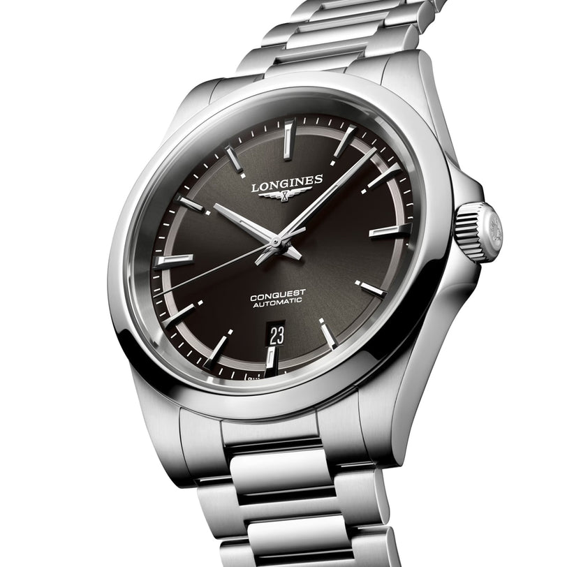 The Longines Conquest features a stainless steel case, black dial with silver hour markers, automatic movement, date at 6 oclock, and a metal bracelet.