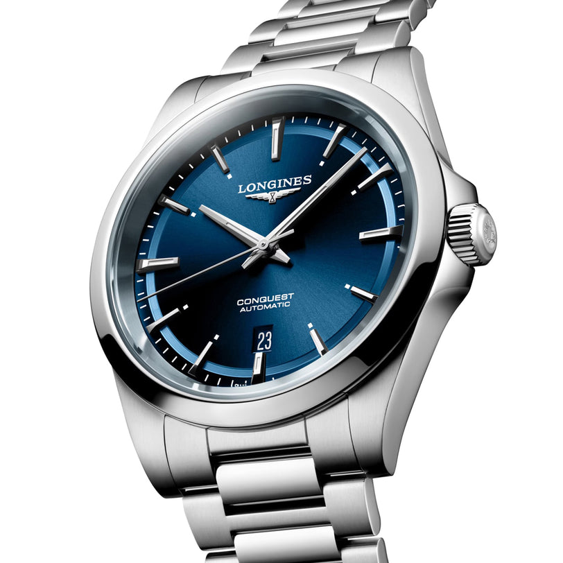 The Longines Conquest is a stainless steel wristwatch with a sunray blue dial, silver hour markers, date at 6 o’clock, and Conquest Automatic on the face. It is powered by the reliable L888 calibre.