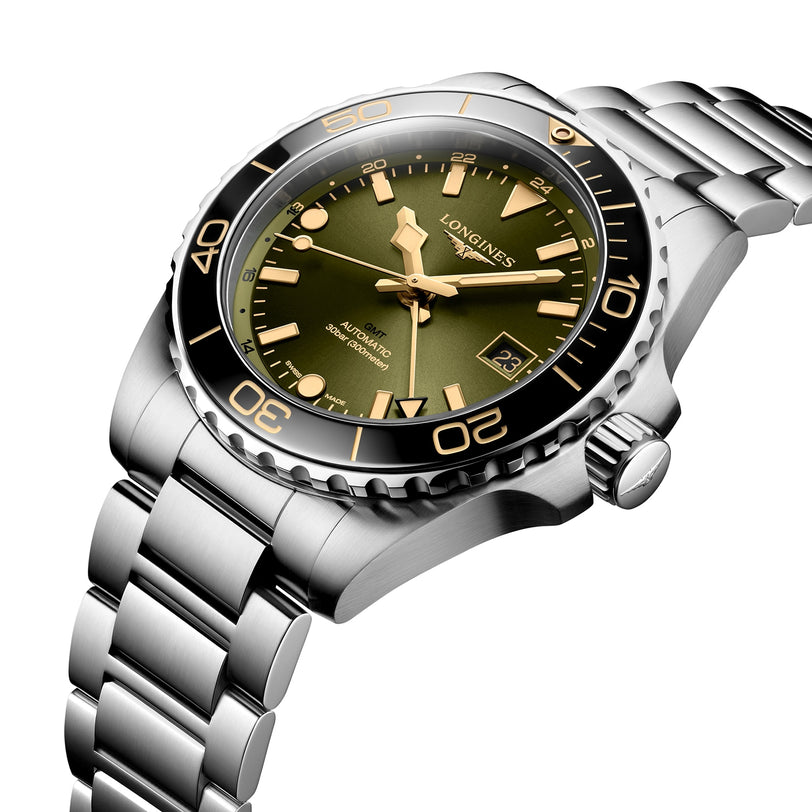 The Longines HydroConquest is a stainless steel diving watch featuring a green dial, gold hour markers, ceramic bezel, and a date window at 3 oclock, displayed at an angle.
