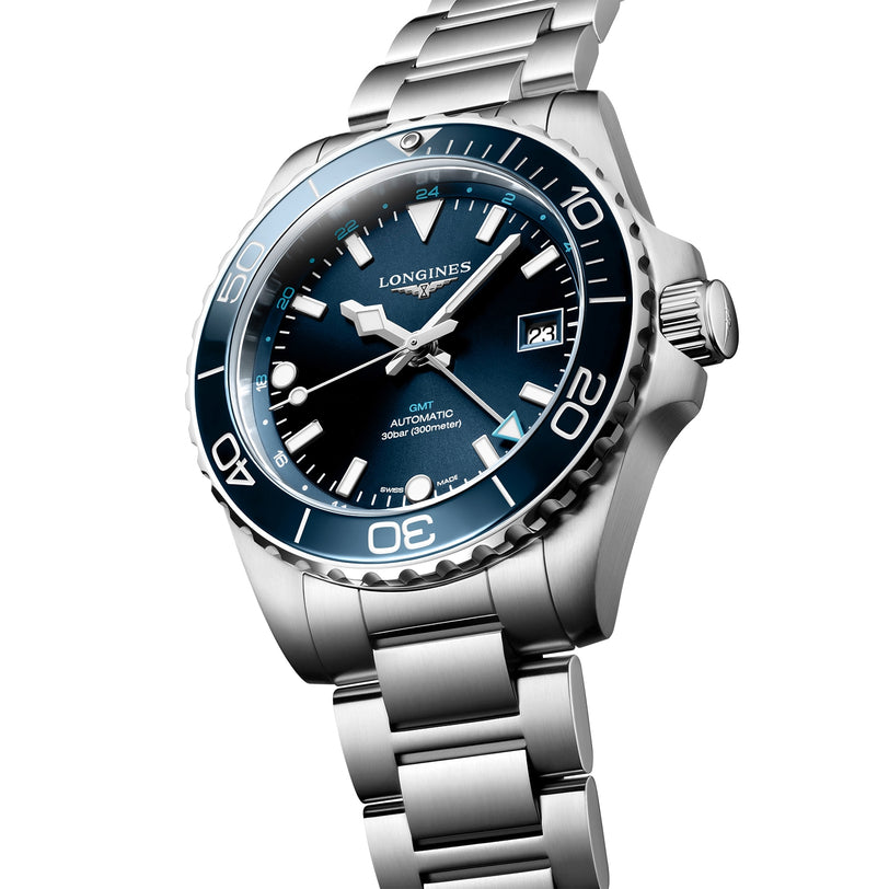 A Longines HydroConquest stainless steel diving watch with a blue dial, date display, rotating bezel, and metal bracelet is displayed at an angle on a white background.