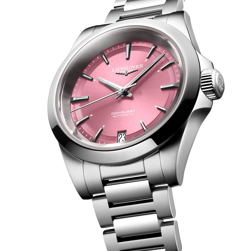 A Longines Conquest automatic wristwatch featuring a stainless steel case, pink dial, silver hour markers, self-winding movement, and a date window at 6 o’clock.