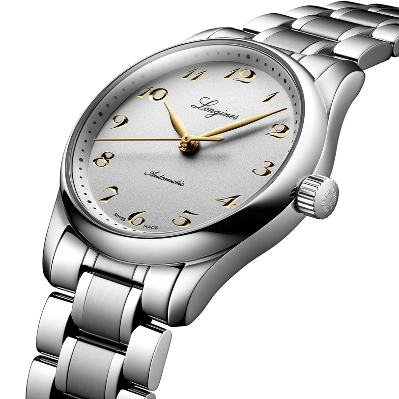 A Longines Master Collection wristwatch with a silver metallic band, gold hour markers and hands, and the brand name on the dial. The classic timepiece displays 10:10, reflecting its automatic movement precision.