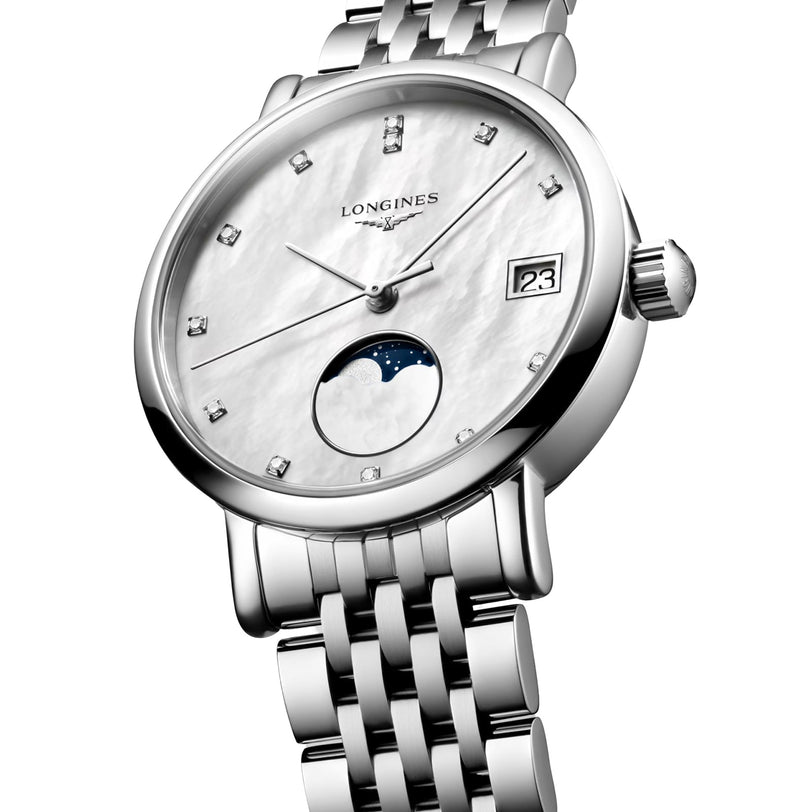 The Longines Elegant Collection Moonphase is a silver wristwatch with a white dial, diamond indexes, date display, moon phase subdial, quartz movement, and a metal link bracelet.