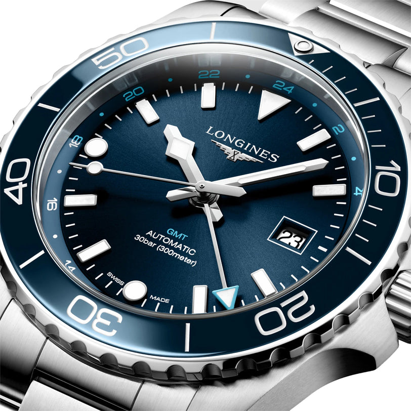 Close-up of the Longines HydroConquest watch, featuring a stainless steel case, blue dial, white hour markers, date at 3 oclock, and a rotating bezel with 24-hour markers.