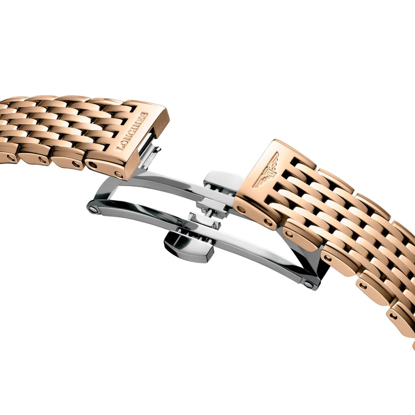 A close-up of a rose gold metal watch bracelet with a butterfly clasp, engraved with the Longines logo from La Grande Classique de LONGINES.
