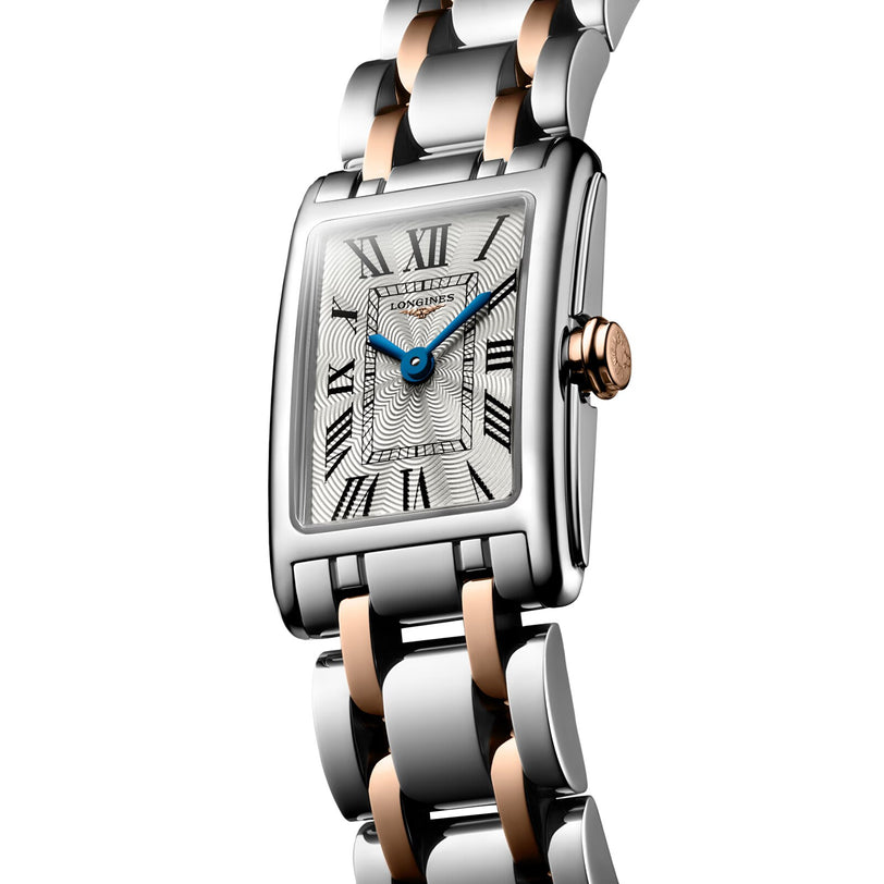The Longines Dolcevite is a rectangular wristwatch in silver and rose gold, featuring Roman numerals and blue hands on a white dial.