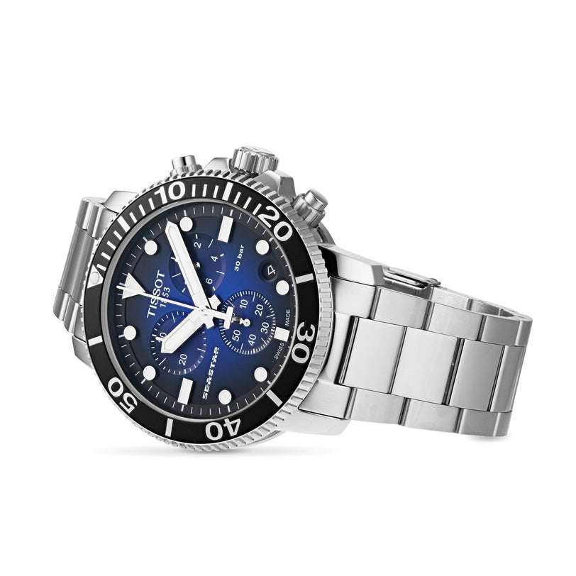 The Tissot Seastar 1000 Chronograph features a striking blue dial, three subdials, and a rotating black bezel in a bold 45.5mm stainless steel case—designed with deep sea exploration inspiration.