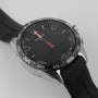 A close-up of the Tissot T-Touch Connect Solar wristwatch highlights its black dial, red compass hand, black rubber strap, titanium case bezel, and features such as navigation, activity tracking, and solar-powered energy reserve.