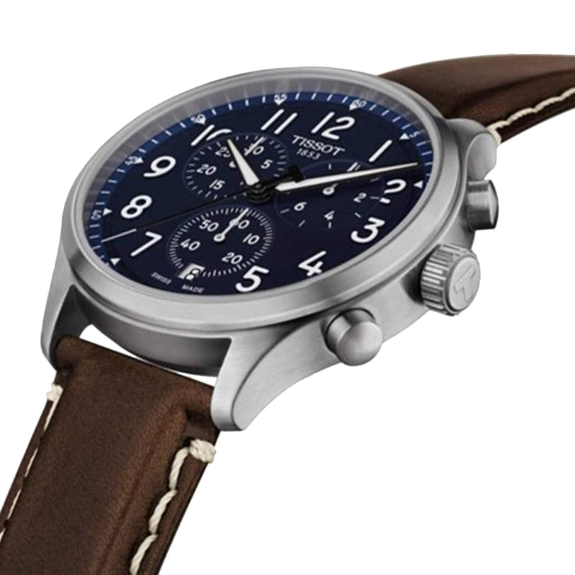 The Tissot Chrono XL Vintage is an elegant timepiece with a blue chronograph dial, stainless steel case, and a brown leather strap featuring white stitching and vintage-inspired style.